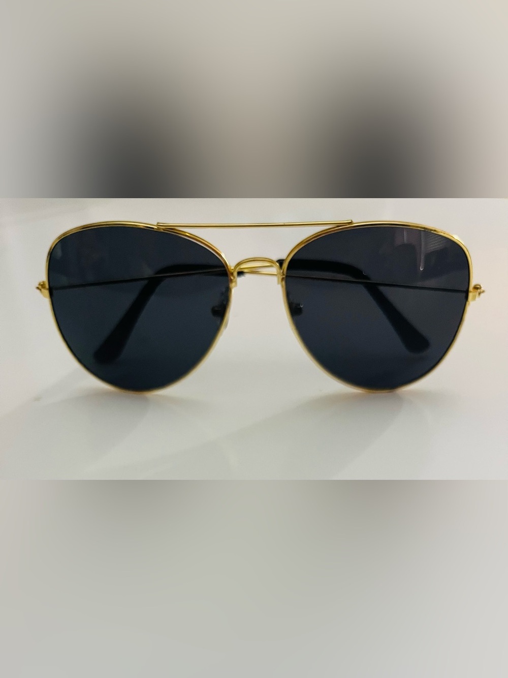 Gold frame aviator sunglasses with dark lenses.
